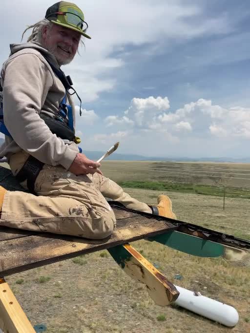 Craig Asher seated while working on a roof